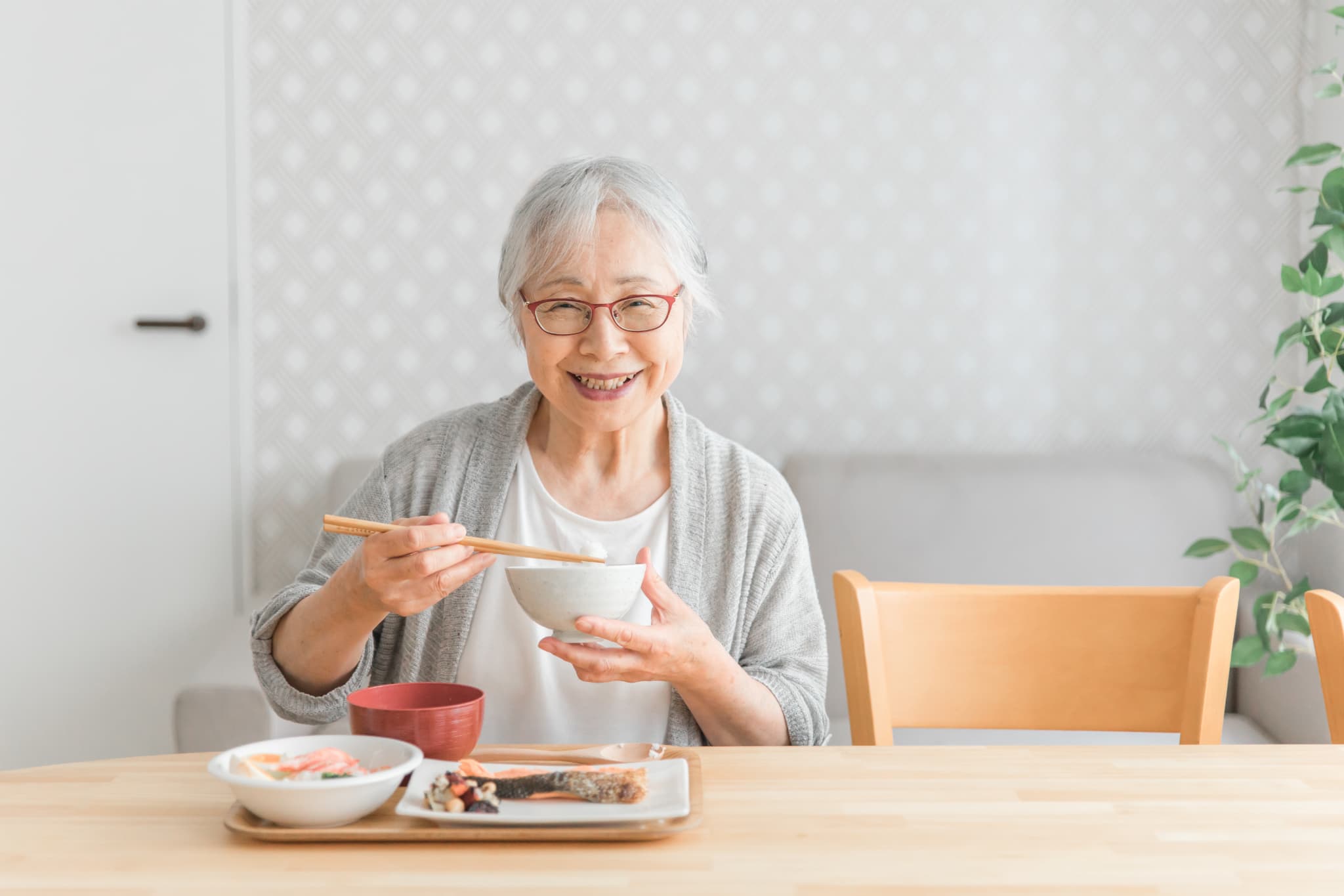 自分に合った入れ歯で美味しく食事をいただく女性