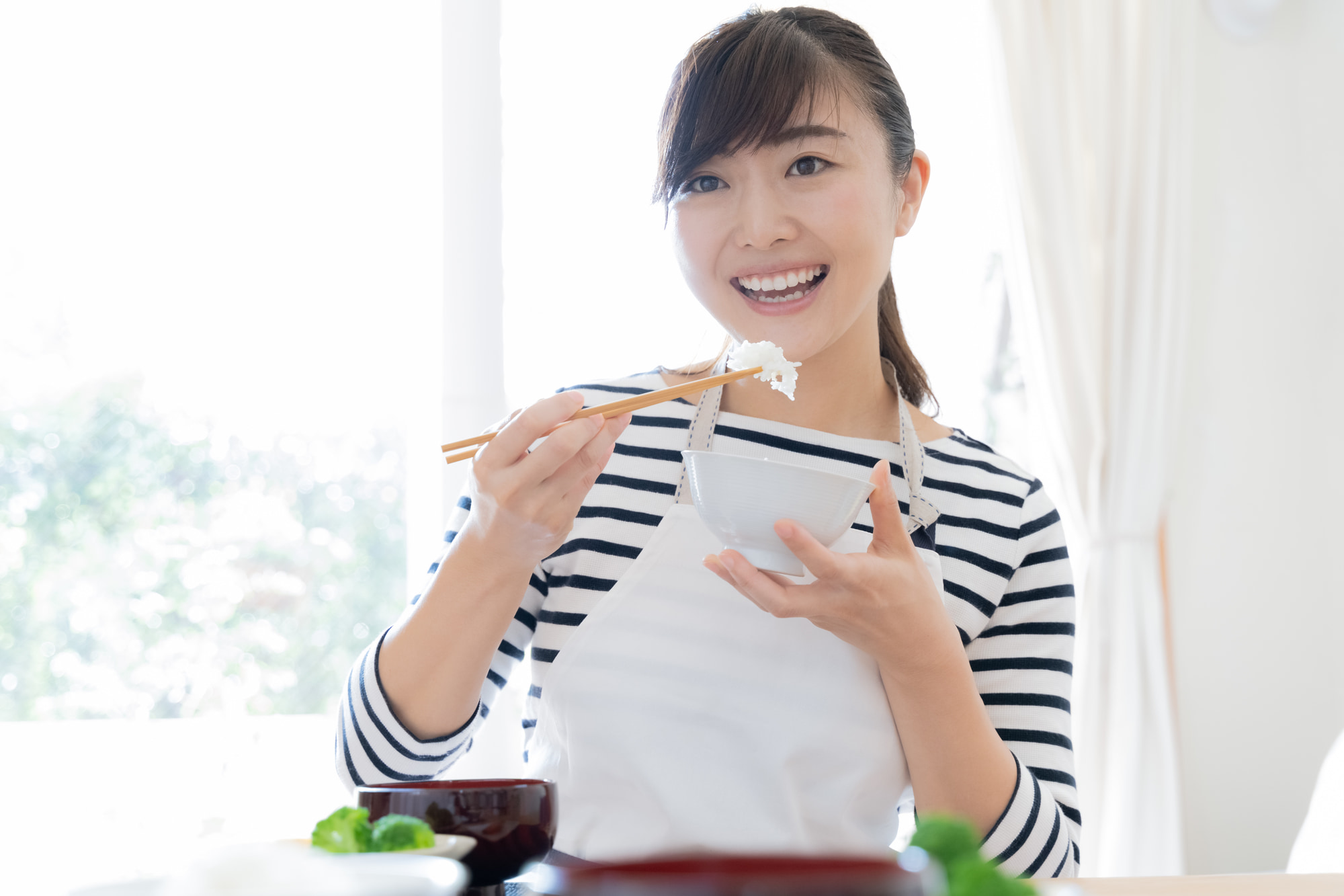 親知らずの治療を終え笑顔で食事をいただく女性