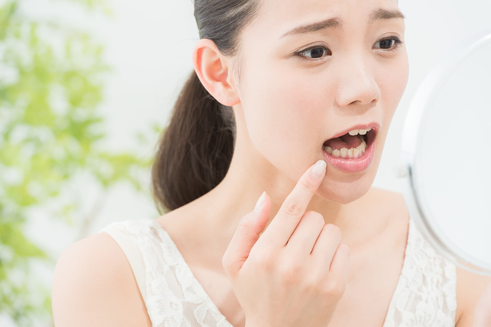 歯周病が気になって鏡を見る女性
