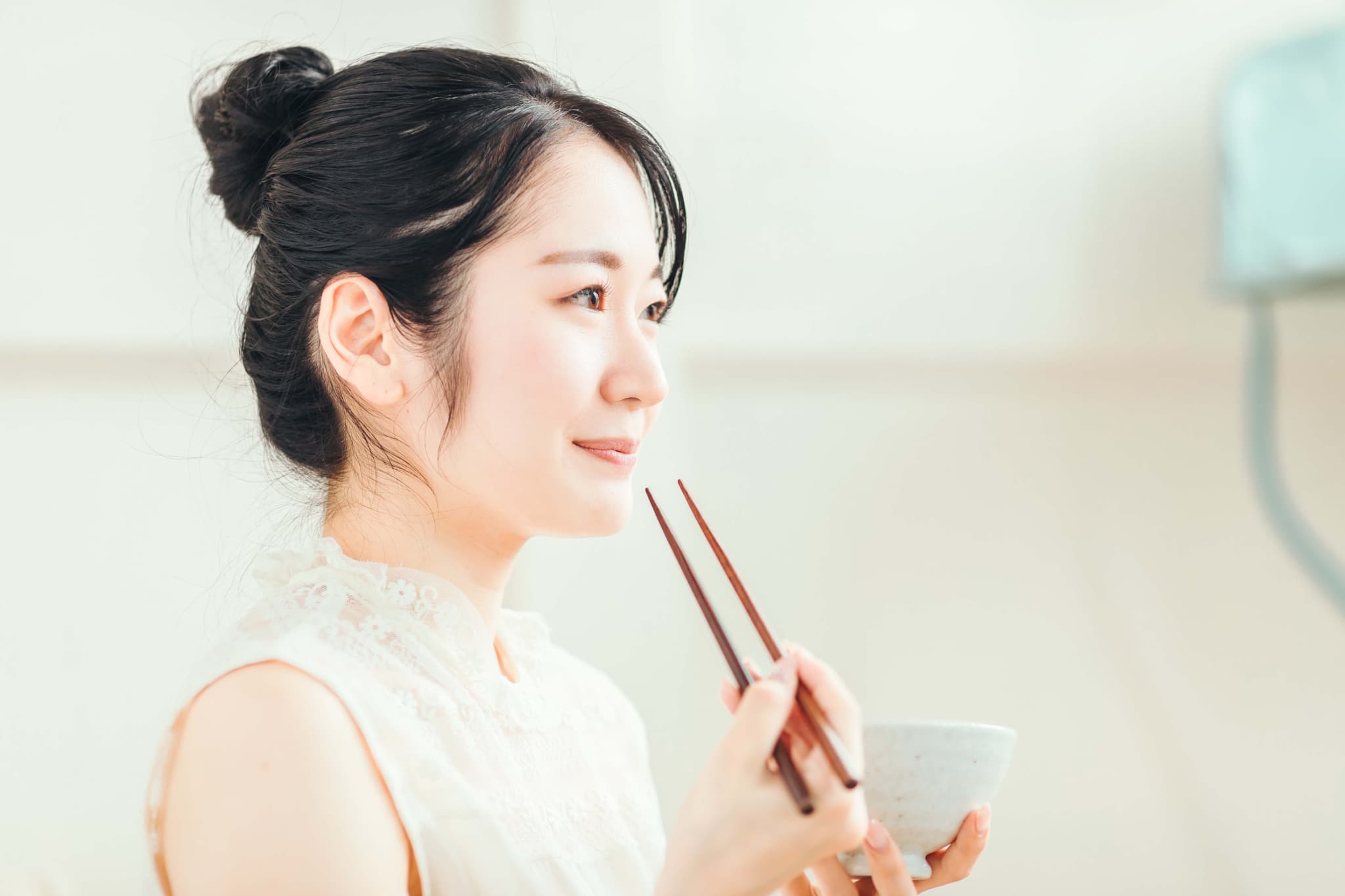 根管治療後に硬い物を噛まないように食事する女性