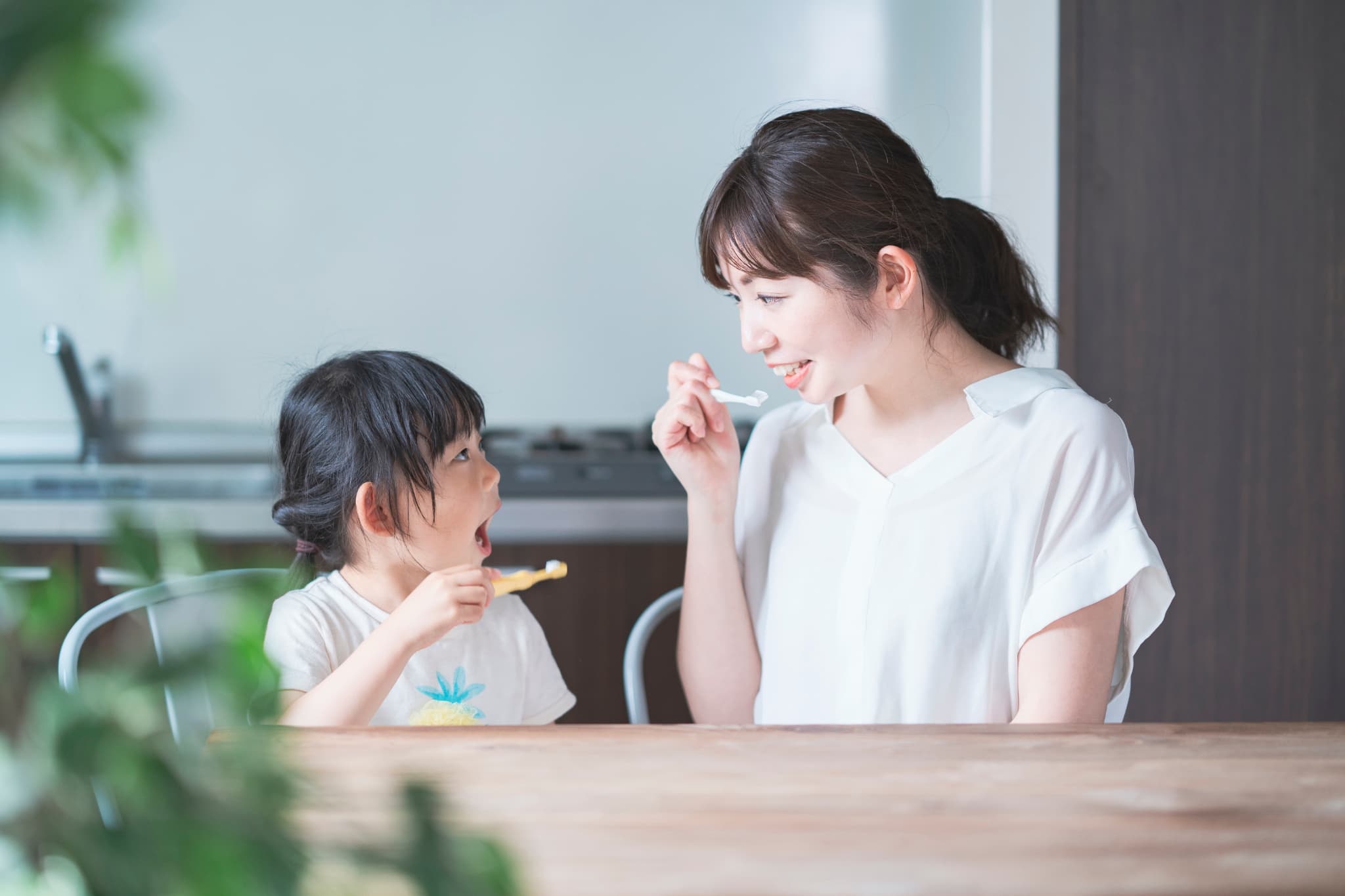 仲良く歯磨きする親子