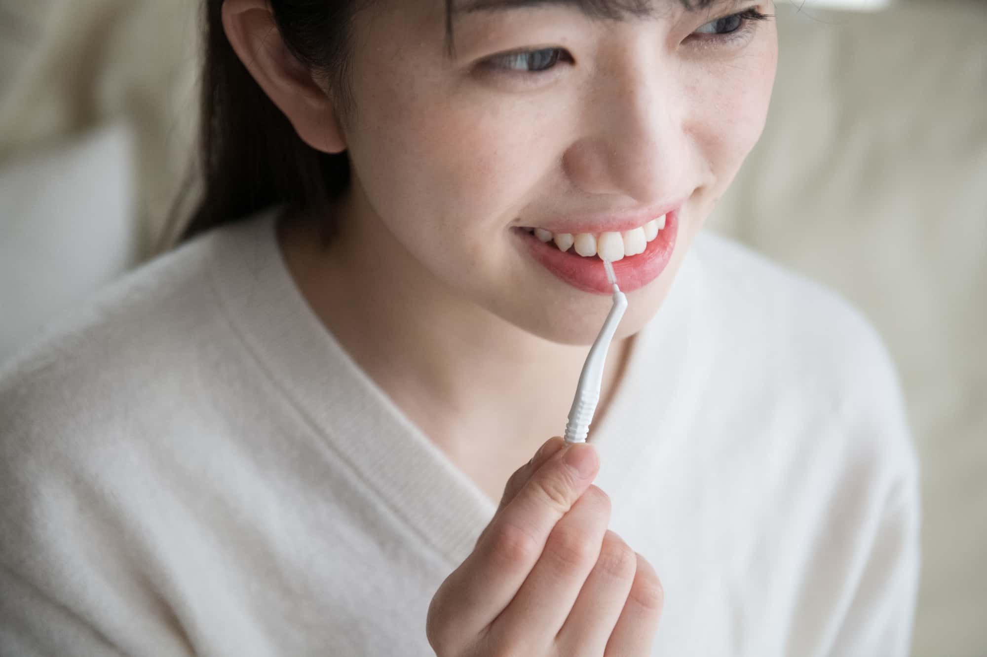 歯周病を予防する為に歯間ブラシを使う女性