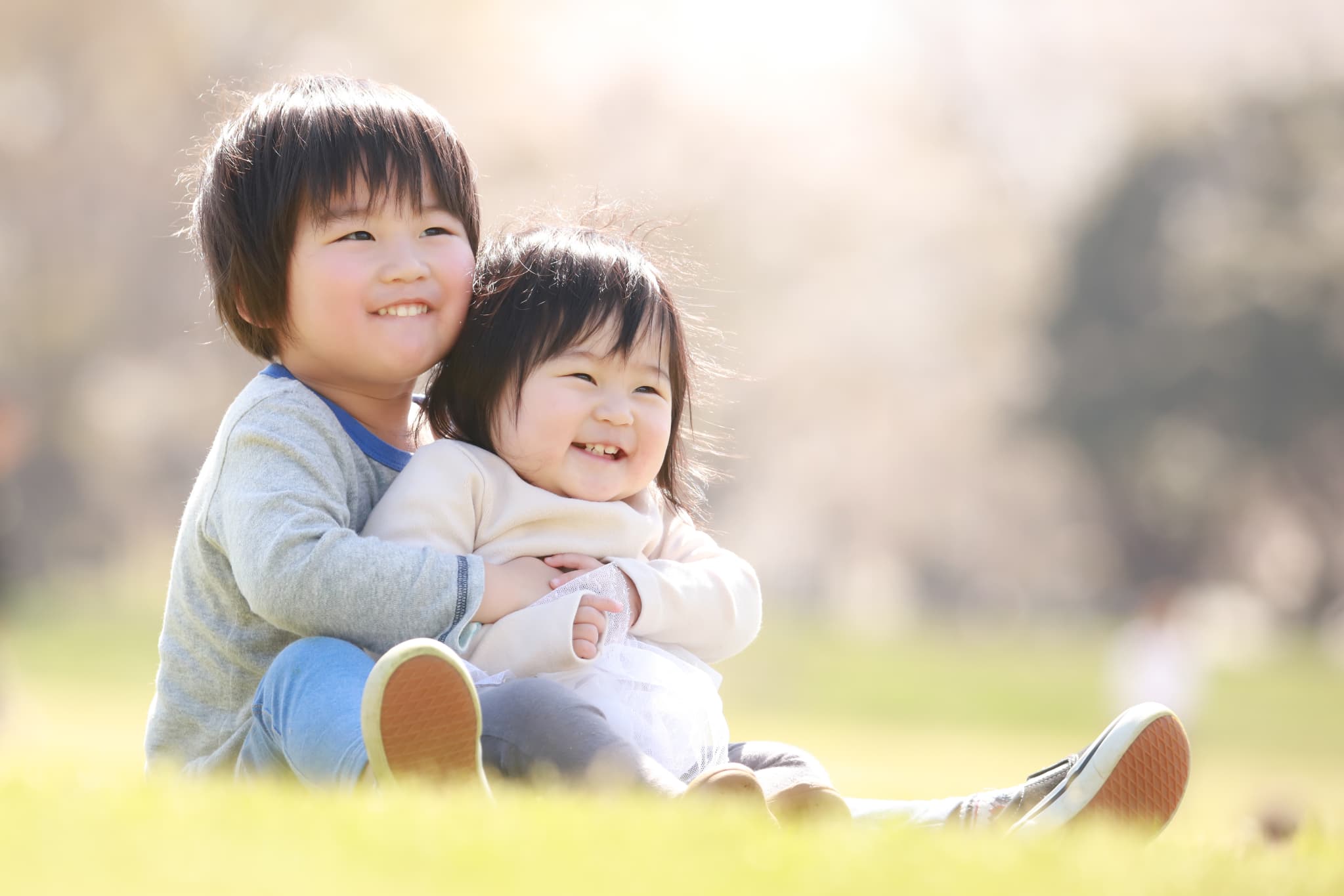 公園で仲良くくっつく幼い兄妹