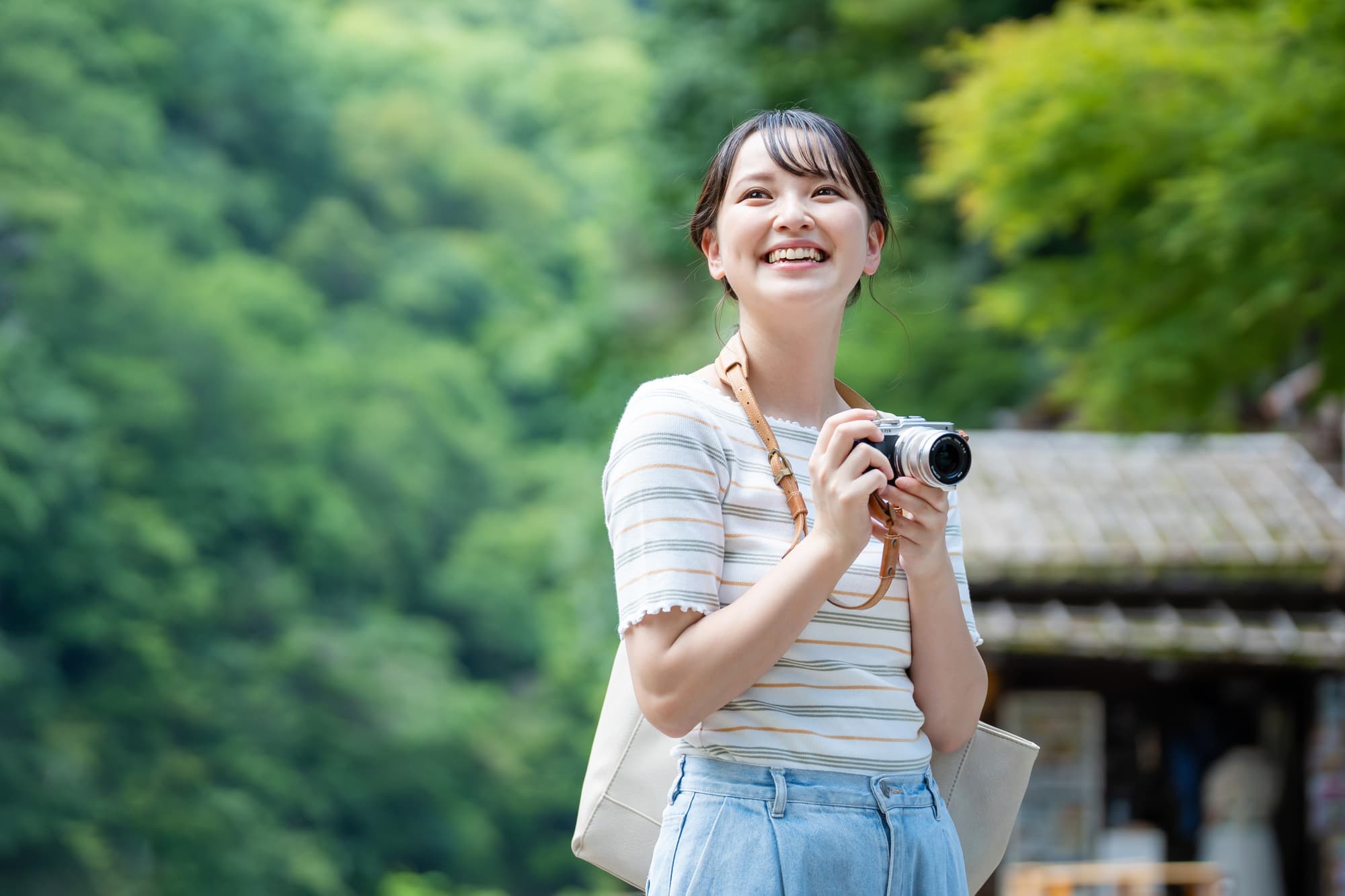趣味のカメラを持っておでかけする笑顔の女性