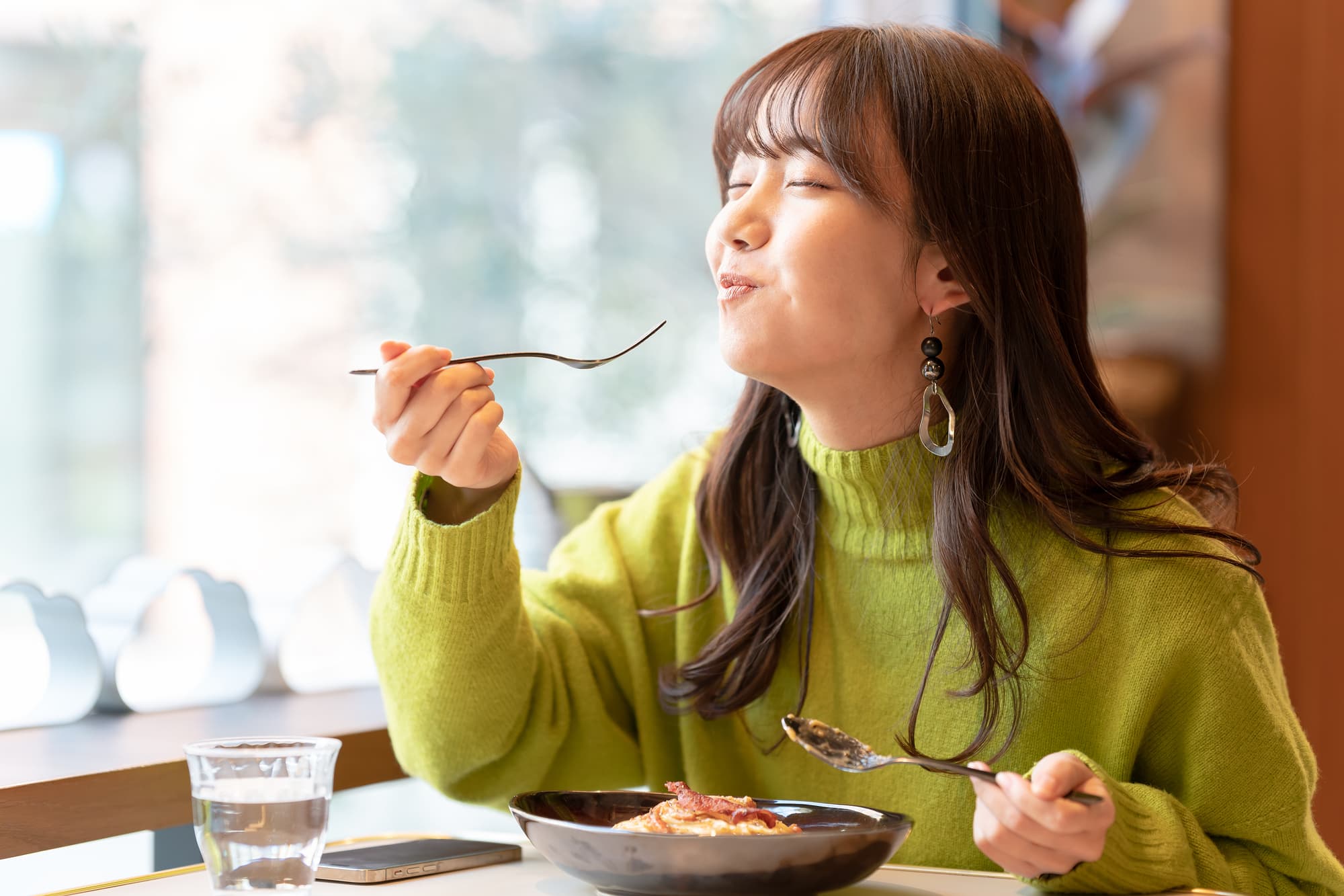 おいしそうに食事する女性
