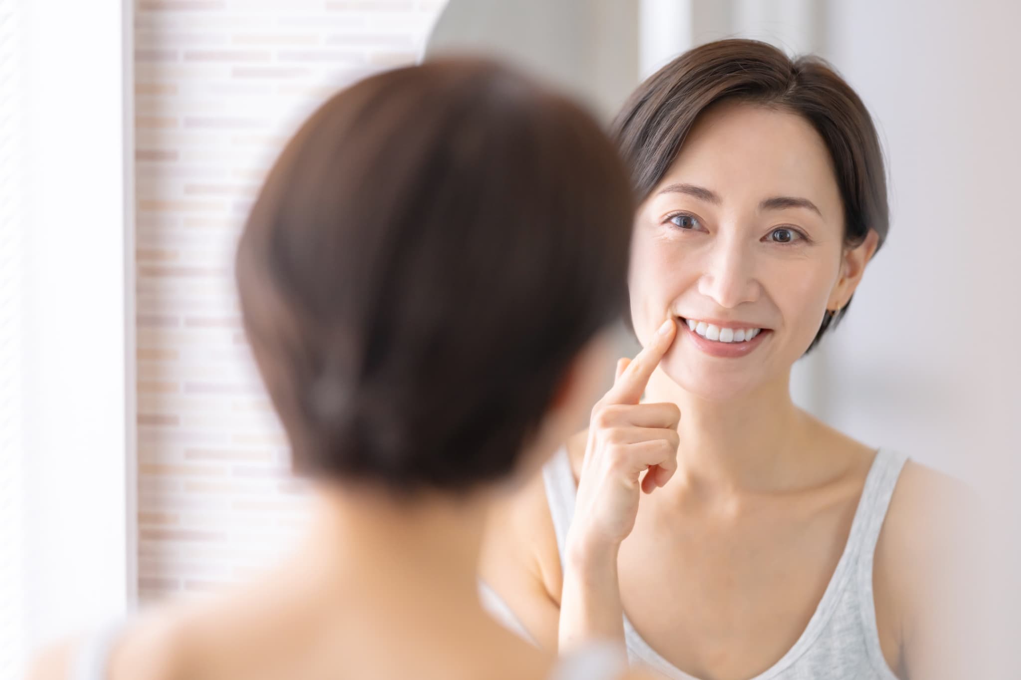 ブリッジ治療後に丁寧に口腔ケアをし口臭を予防する女性