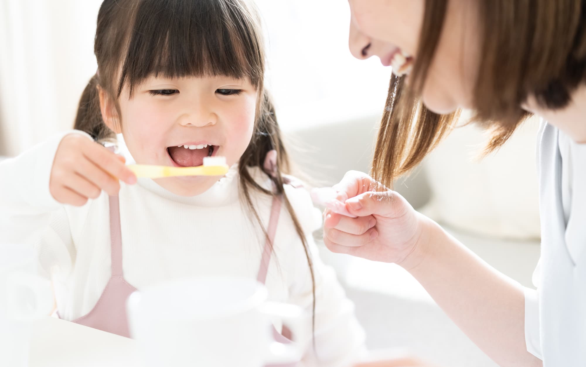 子どもの歯磨きを見守る母親
